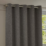 Galaxy Chenille fully lined eyelet curtain in charcoal, textured fabric with silver flecks, hung on a brushed metal pole beside a window.