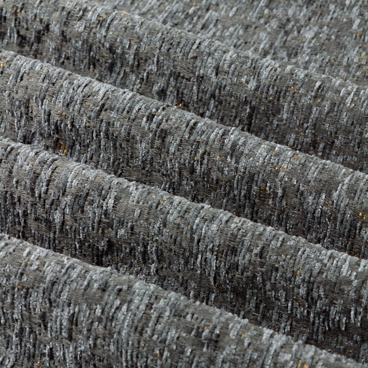 Close-up of Galaxy Chenille Fully Lined Eyelet Curtains in charcoal, showing textured folds with grey-to-black yarn tones and subtle gold flecks catching the light.