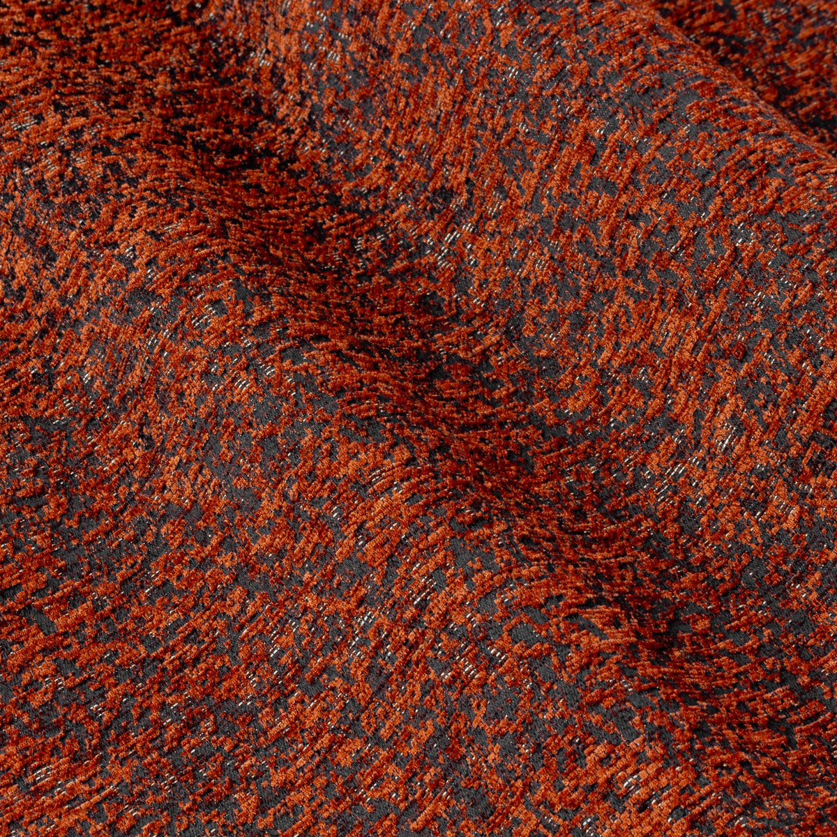 Close-up of Galaxy chenille eyelet curtain fabric in copper, showing a textured rust and dark base weave with glinting golden flecks.
