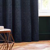Galaxy Chenille Fully Lined Eyelet Curtains in navy, shown as full-length panels with a textured, flecked weave, styled beside a window in a living room setting.