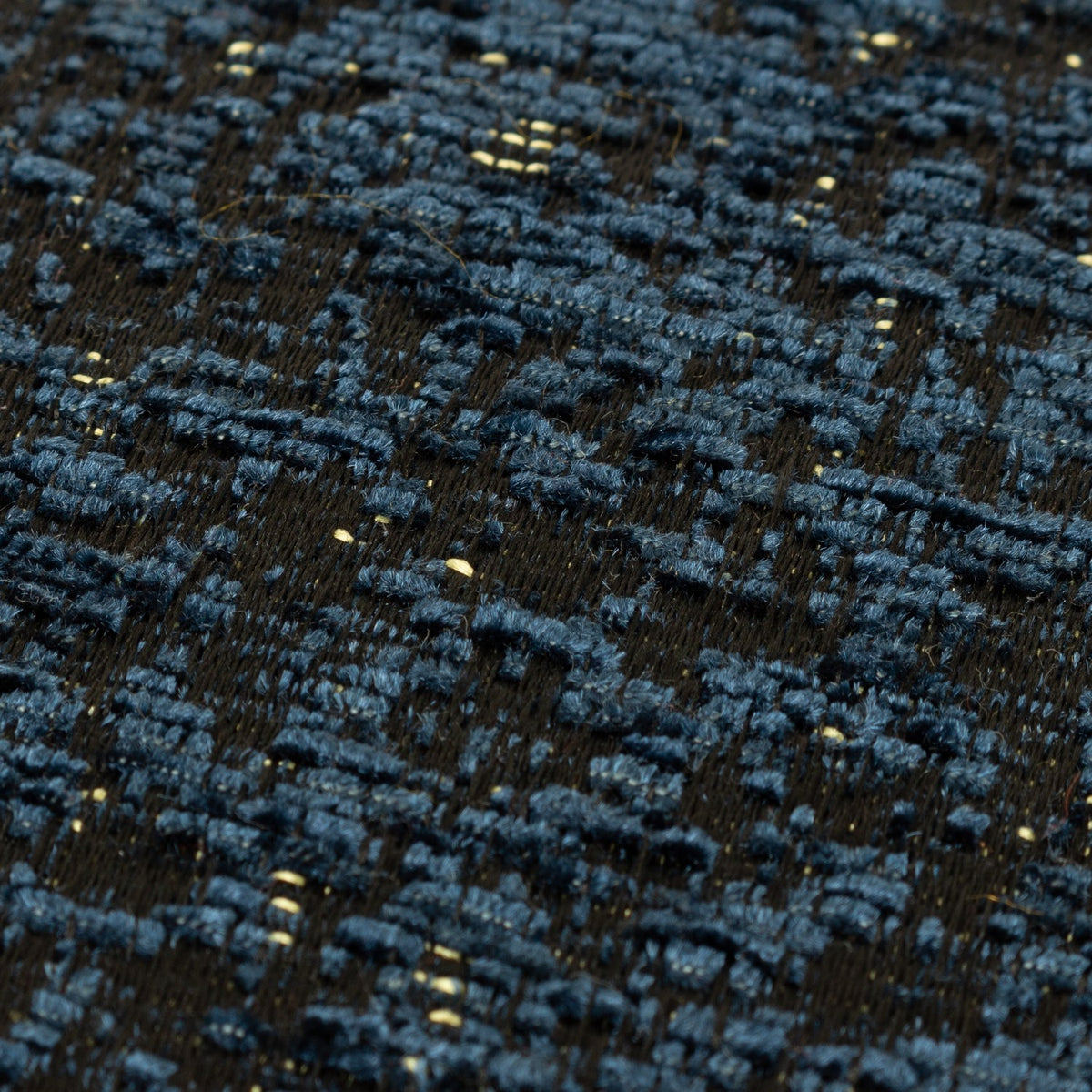 Close-up of the Galaxy Eyelet Chenille Cushion in navy, showing textured chenille yarn with a mottled pattern and subtle golden flecks throughout.