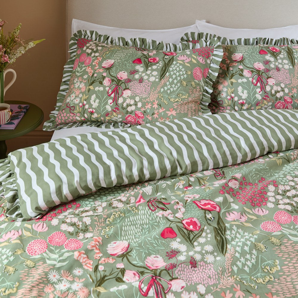 Pink Forest Gardenia reversible duvet cover set with ruffle-trimmed floral pillowcases on sage green, reversing to a green and white wavy stripe.