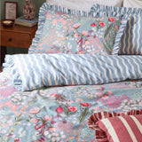 Gardenia Reversible Botanical Duvet Cover Set in Seaspray on a bed, showing the floral rose and tulip print with ruffled edges alongside the reverse wavy stripe pillowcase.