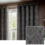 Gatsby Jacquard Lined Eyelet Curtains in black, hung on a gold pole by a window, showing a feathered Art Deco pattern in champagne and gold tones, with a matching fabric swatch shown alongside.
