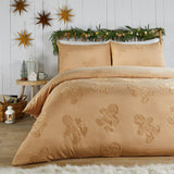Ginger-tone duvet cover set with tufted gingerbread man design, styled on a bed with matching pillowcases in a festive bedroom with hanging star decorations.
