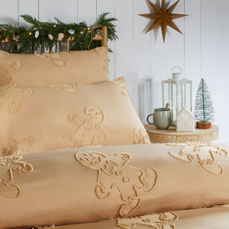 Ginger-toned duvet cover set with tufted gingerbread figures in raised pile, shown on a bed with matching pillowcases in a festive bedroom setting.