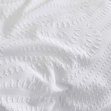 Close-up of the Georgia Woven Polycotton Duvet Cover in white, showing a raised heat-pressed textured pattern in wavy striped rows across the fabric surface.