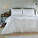 White Ghostly Ghouls duvet cover set with tufted ghost motifs and matching pillowcases on a bed, styled in a bedroom with candles and Halloween accents.
