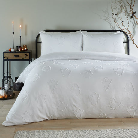 White Ghostly Ghouls duvet cover set with tufted ghost motifs and matching pillowcases on a bed, styled in a bedroom with candles and Halloween accents.