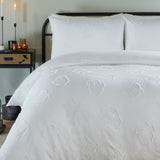 White Ghostly Ghouls duvet cover set on a bed with matching pillowcases, tufted ghost motifs in tonal white polyester, styled in a bedroom with candles.