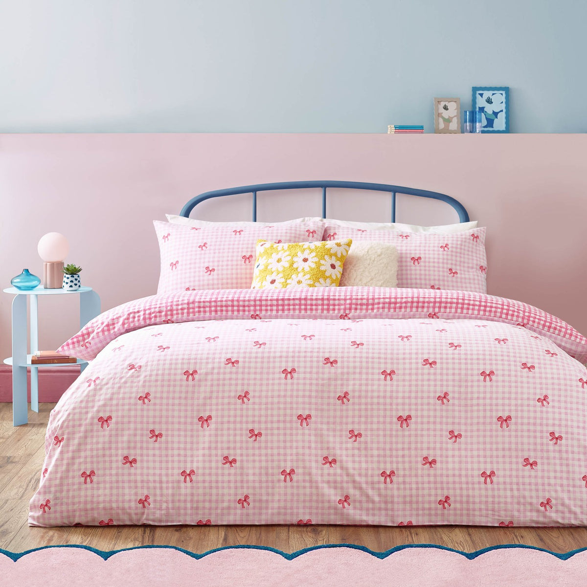 Gingham Bows Reversible Check Duvet Cover Set in pink, dressed on a bedroom bed with matching pillowcases, pink bow-print gingham front and bold check reverse.