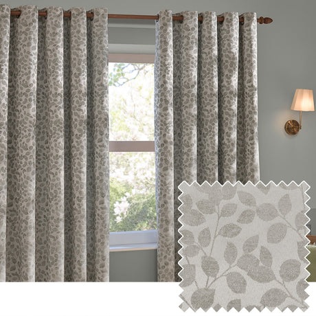 Grace Leaf Jacquard fully lined eyelet curtains in mist grey, shown hung on a wooden pole beside a window, with a woven leaf pattern and matching fabric swatch inset.
