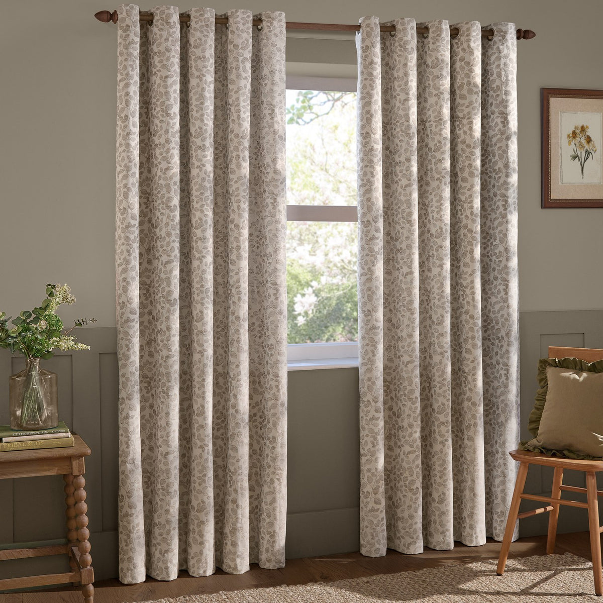 Grace Leaf Jacquard fully lined eyelet curtains in natural, showing a leaf jacquard pattern hung on a wooden pole beside a bedroom or living room window.
