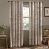Grace Leaf Jacquard fully lined eyelet curtains in natural, showing a leaf jacquard pattern hung on a wooden pole beside a bedroom or living room window.