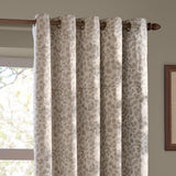 Grace Leaf Jacquard eyelet curtains in natural, showing woven leaf-branch pattern on a wooden pole with round eyelet rings, hung by a bright window.