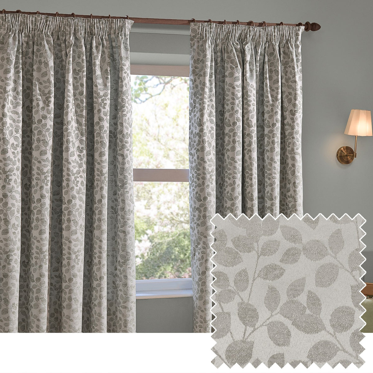 Grace Leaf Jacquard pencil pleat curtains in mist grey, shown hanging beside a window with a leaf-patterned weave, alongside a matching fabric swatch.