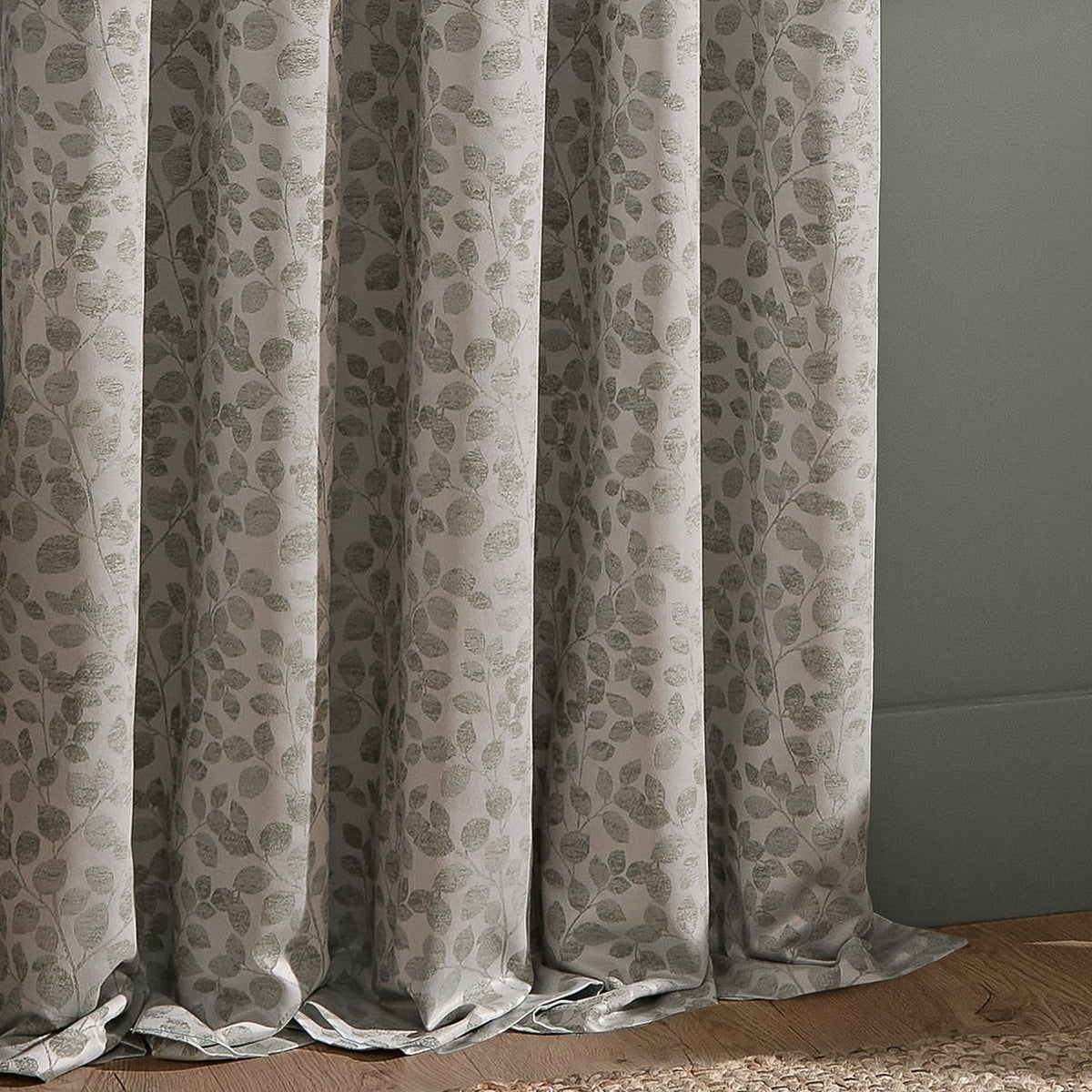 Grace Leaf Jacquard pencil pleat curtains in mist grey, showing draped folds with a woven leaf and stem pattern in a matt satin polyester finish.