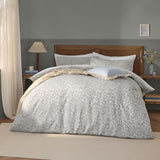 Grace Leaf Jacquard Floral Duvet Cover Set in mist grey, styled on a bed with matching pillowcases and cushions in a bedroom setting, showing the woven trailing leaf pattern.