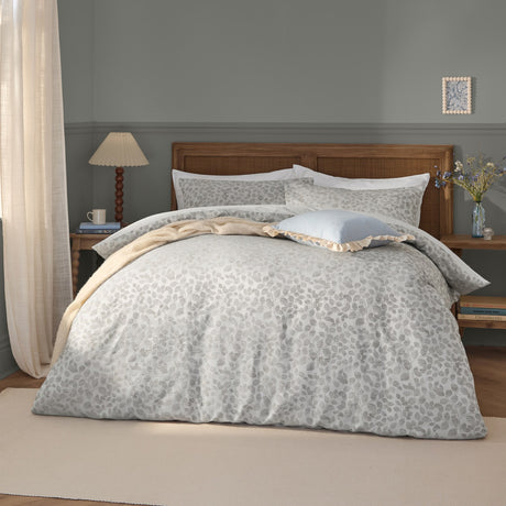 Grace Leaf Jacquard Floral Duvet Cover Set in mist grey, styled on a bed with matching pillowcases and cushions in a bedroom setting, showing the woven trailing leaf pattern.