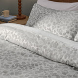 Grace Leaf Jacquard Floral Duvet Cover Set in mist grey, shown on a bed with matching pillowcase, woven leaf pattern in a satin jacquard finish, styled in a bedroom setting.