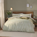Grace Leaf Jacquard Floral Duvet Cover Set in sage, styled on a bed with matching pillowcases and a leaf-patterned jacquard design in a wood-panelled bedroom.