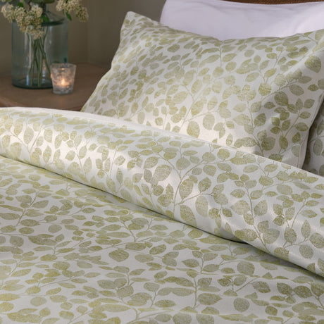 Grace Leaf Jacquard Floral Duvet Cover Set in sage, shown on a bed with matching pillowcase in a woven leaf pattern on a cream ground, styled in a bedroom setting.
