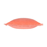 Gracie Velvet Cotton Cushion in coral, shown side-on to reveal its plump square shape and fringed trim edging, set against a plain white background.