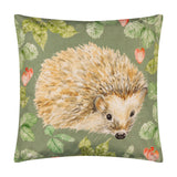 Square olive green polyester cushion featuring a hand-painted hedgehog design surrounded by strawberries and leaves, shown on a plain white background.