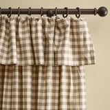 Harriet Gingham cotton pencil pleat curtains in buttermilk and chocolate check, showing the ruffled flop-top header gathered on a dark curtain rod with rings.