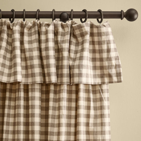 Harriet Gingham cotton pencil pleat curtains in buttermilk and chocolate check, showing the ruffled flop-top header gathered on a dark curtain rod with rings.