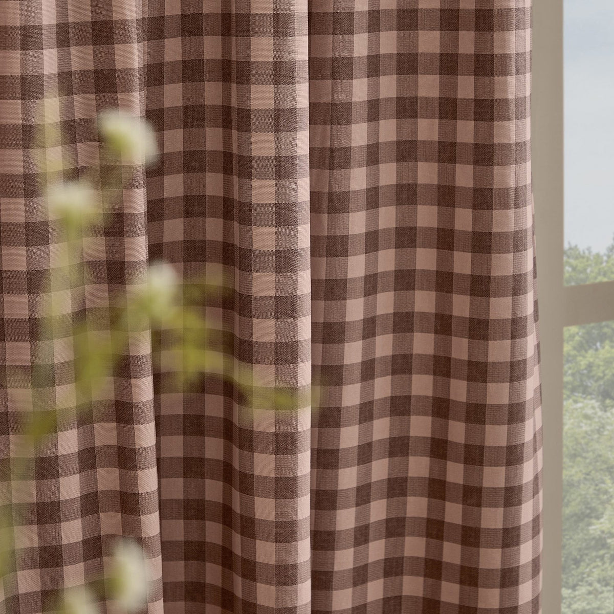 Harriet Gingham Cotton Pencil Pleat Curtains in rose pink and chocolate brown check, shown hanging in pencil pleat header folds beside a window in a living space.