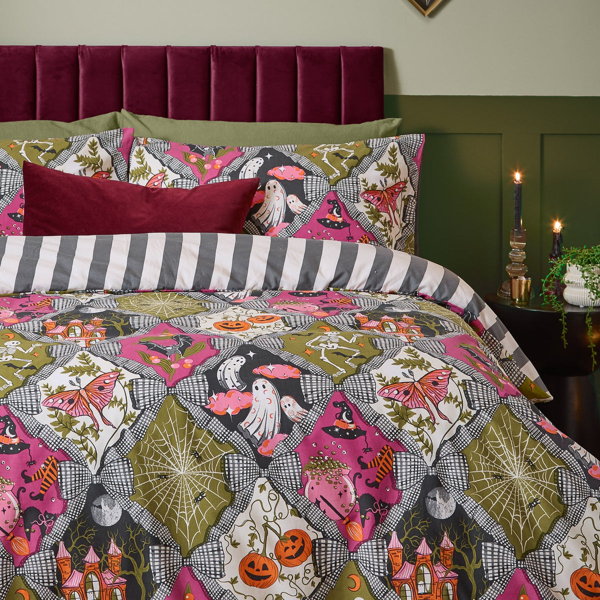 Reversible Halloween duvet cover set with matching pillowcases, printed with ghosts, pumpkins, skeletons and cobwebs in pink, olive and grey diamond panels, reversing to grey and white stripes.
