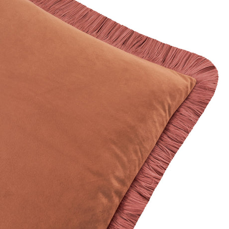 Close-up of the Halo Fringed Velvet Cushion in chestnut, showing the plain velvet square corner with a dusky slipper-pink fringed trim, against a plain white background.