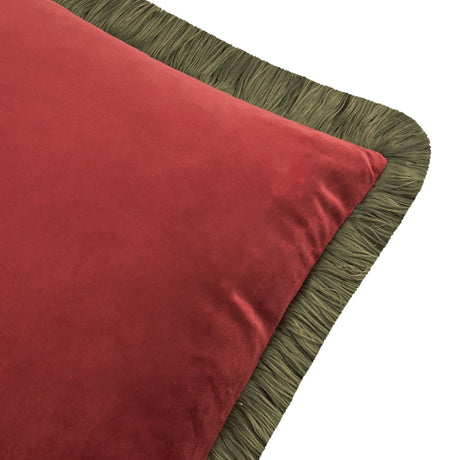 Close-up of the Halo Fringed Velvet Cushion showing dark red velvet fabric with a fir green fringed trim along the edge, on a white background.