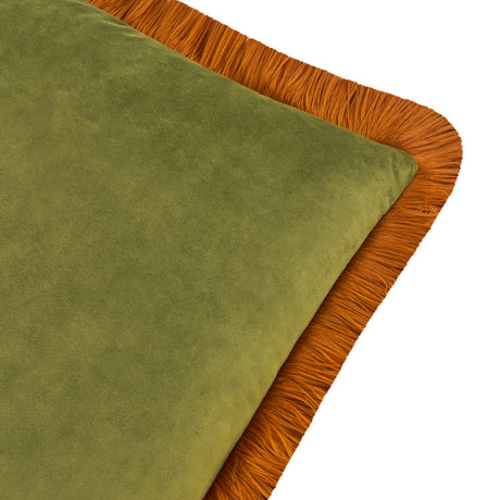Close-up of the Halo Fringed Velvet Cushion in olive green velvet with a contrasting ginger fringe trim along all edges, shown on a plain white background.