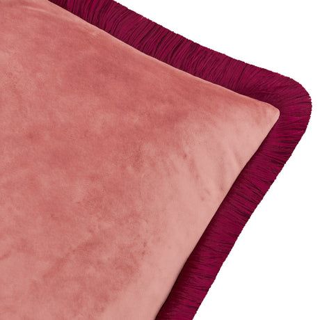 Close-up of the Halo Fringed Velvet Cushion showing its slipper-pink velvet face and deep burgundy fringe trim along the edge, on a plain white background.