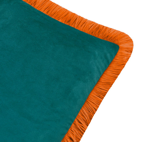 Close-up of the Halo Fringed Velvet Cushion in teal, showing the plain velvet face and tiger-orange fringed trim along the edge, on a plain white background.