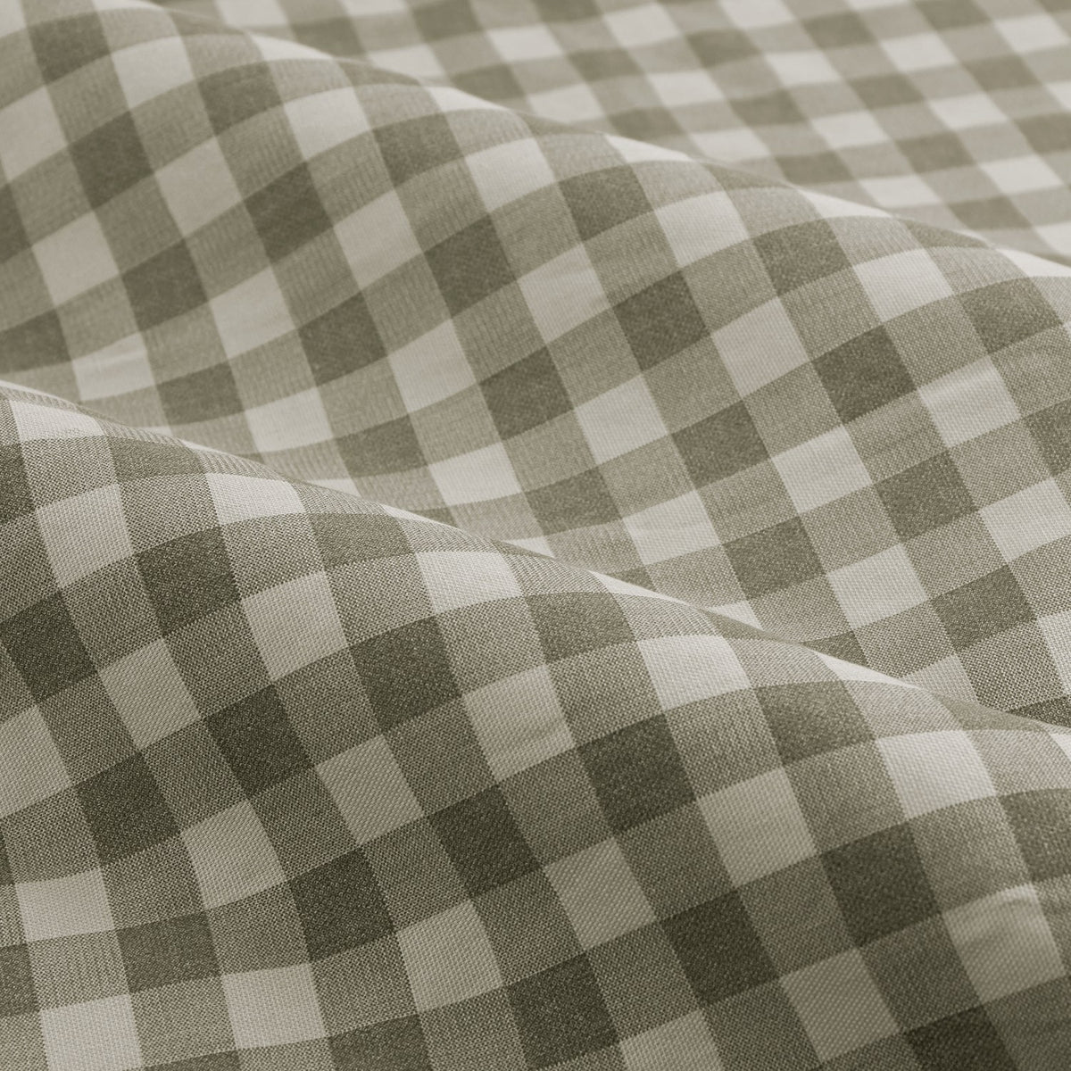 Close-up of Harriet Gingham cotton pencil pleat curtain fabric, showing a sage-grey and cream checked pattern in soft draped folds.