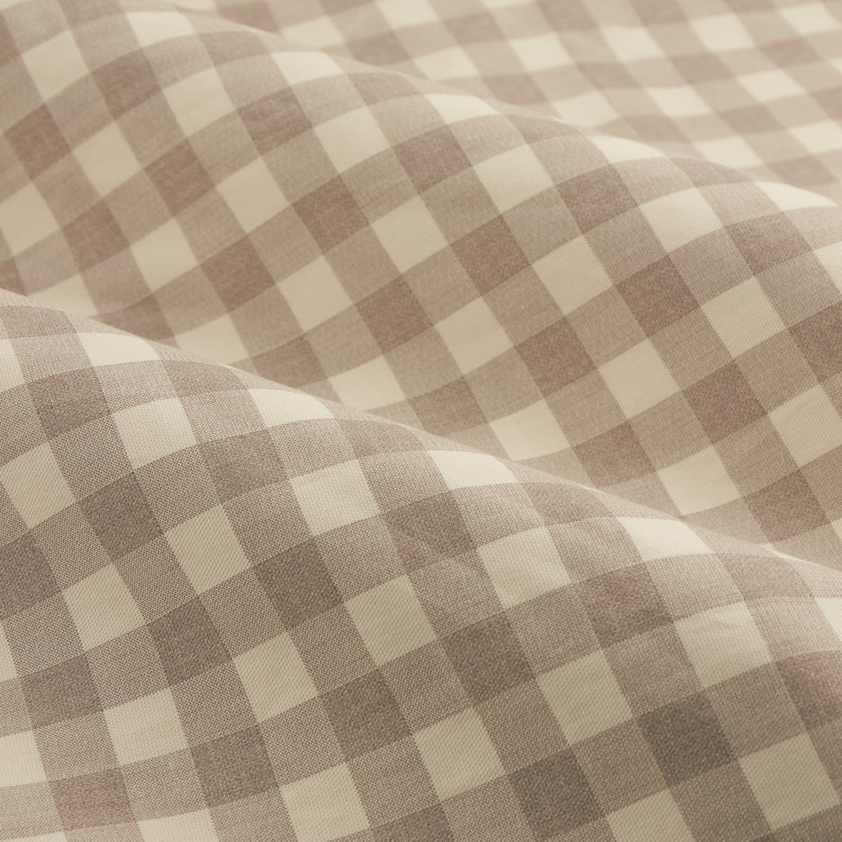 Close-up of Harriet Gingham Cotton Pencil Pleat Curtains fabric, showing a tonal natural beige and cream check pattern across softly draped folds.