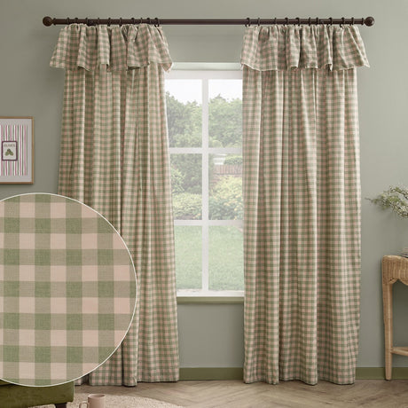 Harriet Gingham Cotton Pencil Pleat Curtains in pink and green check with ruffled flop-top header, hung on a dark rod in a sage green living room, with a fabric swatch inset.