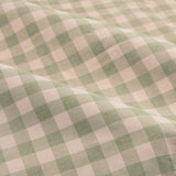 Close-up of Harriet Gingham Cotton Pencil Pleat Curtains fabric, showing a pink and green check pattern in soft folds.