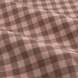 Close-up of Harriet Gingham Cotton Pencil Pleat Curtains fabric, showing draped folds in a rose and chocolate brown check pattern woven from 100% cotton.