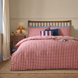 Harriet Gingham Cotton Check Duvet Cover Set in Burgundy/Blossom on a bed with matching pillowcases, striped and navy velvet cushions, in a bedroom setting.