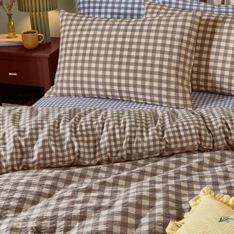 Harriet Gingham Check Duvet Cover Set in Buttermilk/Chocolate, shown in a bedroom with matching pillowcases in seersucker cotton gingham check on a made bed.