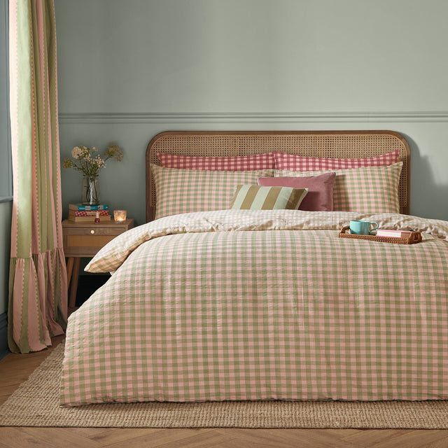 Harriet Gingham Cotton Check Duvet Cover Set in pink and green, styled on a bed with matching pillowcases and striped and velvet cushions in a bedroom setting.