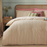 Harriet Gingham Cotton Check Duvet Cover Set in pink and green seersucker check, styled on a bed with matching pillowcases and coordinating cushions in a bedroom setting.