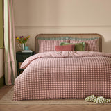 Harriet Gingham Cotton Check Duvet Cover Set in Rose/Chocolate, styled on a bed with matching pillowcases, velvet cushions, and a rattan headboard in a bedroom setting.
