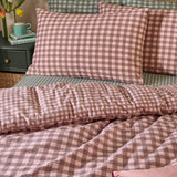 Harriet Gingham Cotton Check Duvet Cover Set in Rose/Chocolate, shown on a bed with matching pillowcases in a seersucker check, styled in a bedroom with a green nightstand and books.