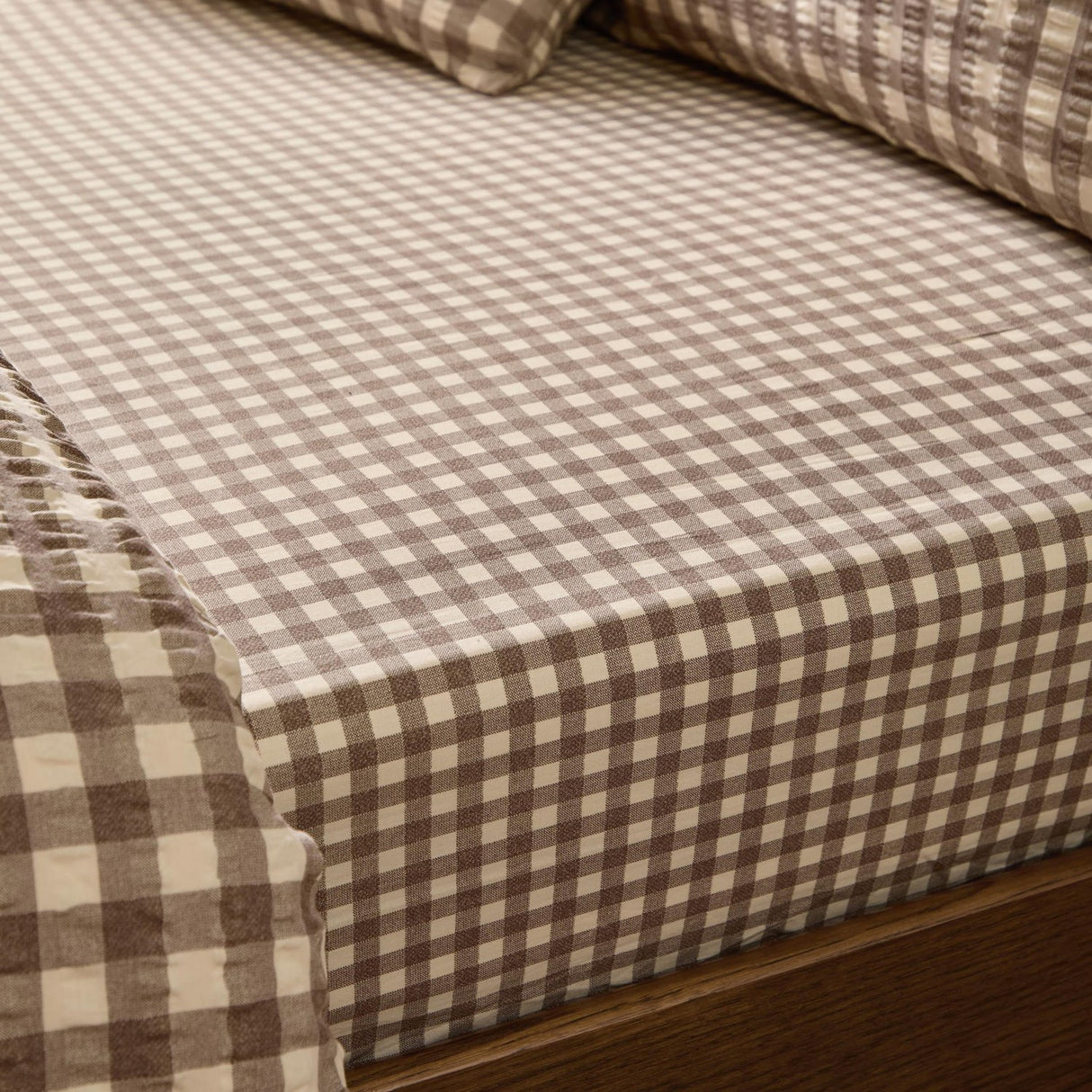 Harriet Gingham Check Cotton Fitted Sheet in buttermilk and chocolate, fitted on a mattress with matching pillowcases, showing the small woven check pattern.