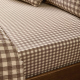 Harriet Gingham Check Cotton Fitted Sheet in buttermilk and chocolate, fitted on a mattress with matching pillowcases, showing the small woven check pattern.
